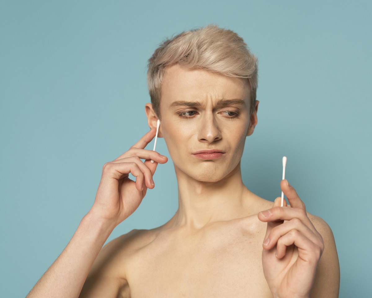 Woman looking disgusted while holding two cotton swabs