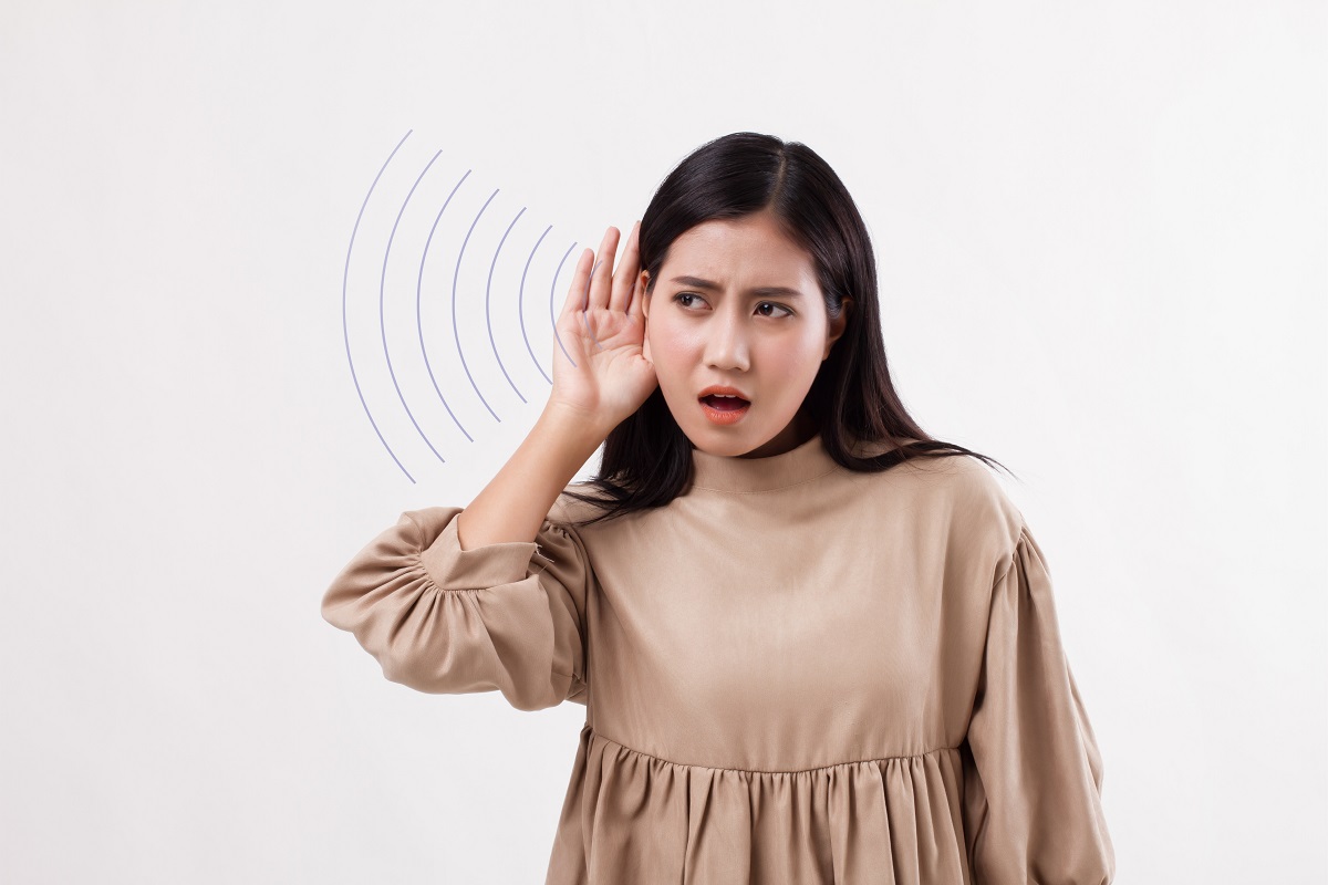 sound waves illustration next to a woman cupping her ear