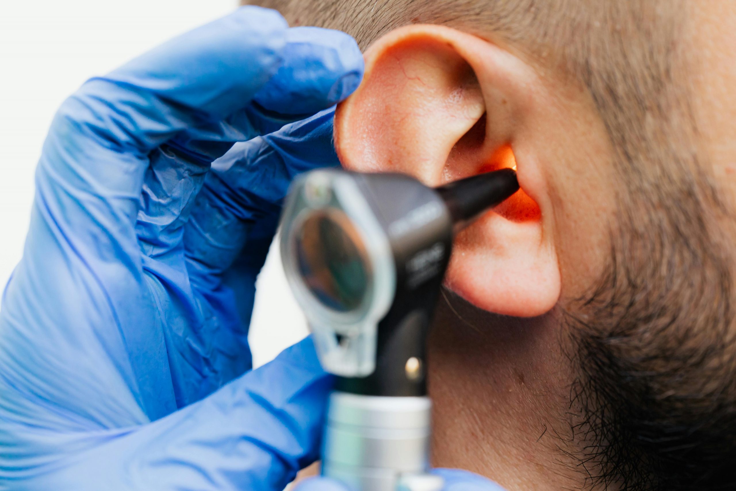 doctor using an otoscope to examine a patient's ear